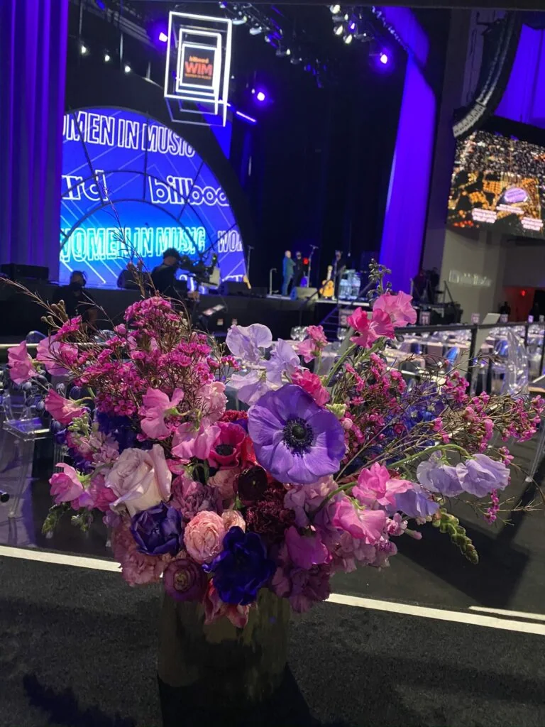 Purple and pink floral arrangement in front of the Billboard Women in Music stage